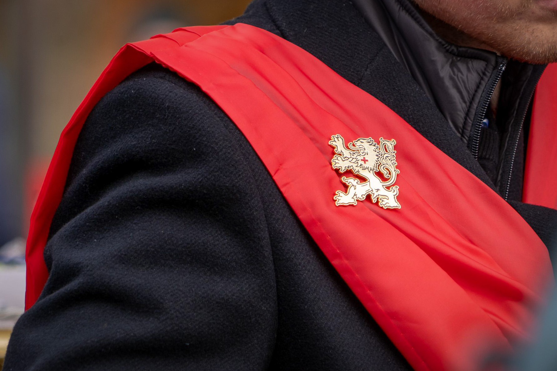 Das Logo von „Tradition, Familie, Privateigentum“, auf der roten Schärpe eines TFP-Anhängers. Foto: Lina Dahm