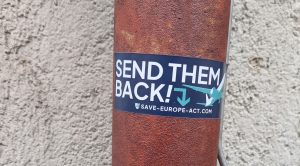 Das Foto zeigt den blau-weißen Sticker mit der Aufschrift „Send them back!“ am Fallrohr einer Regenrinne.